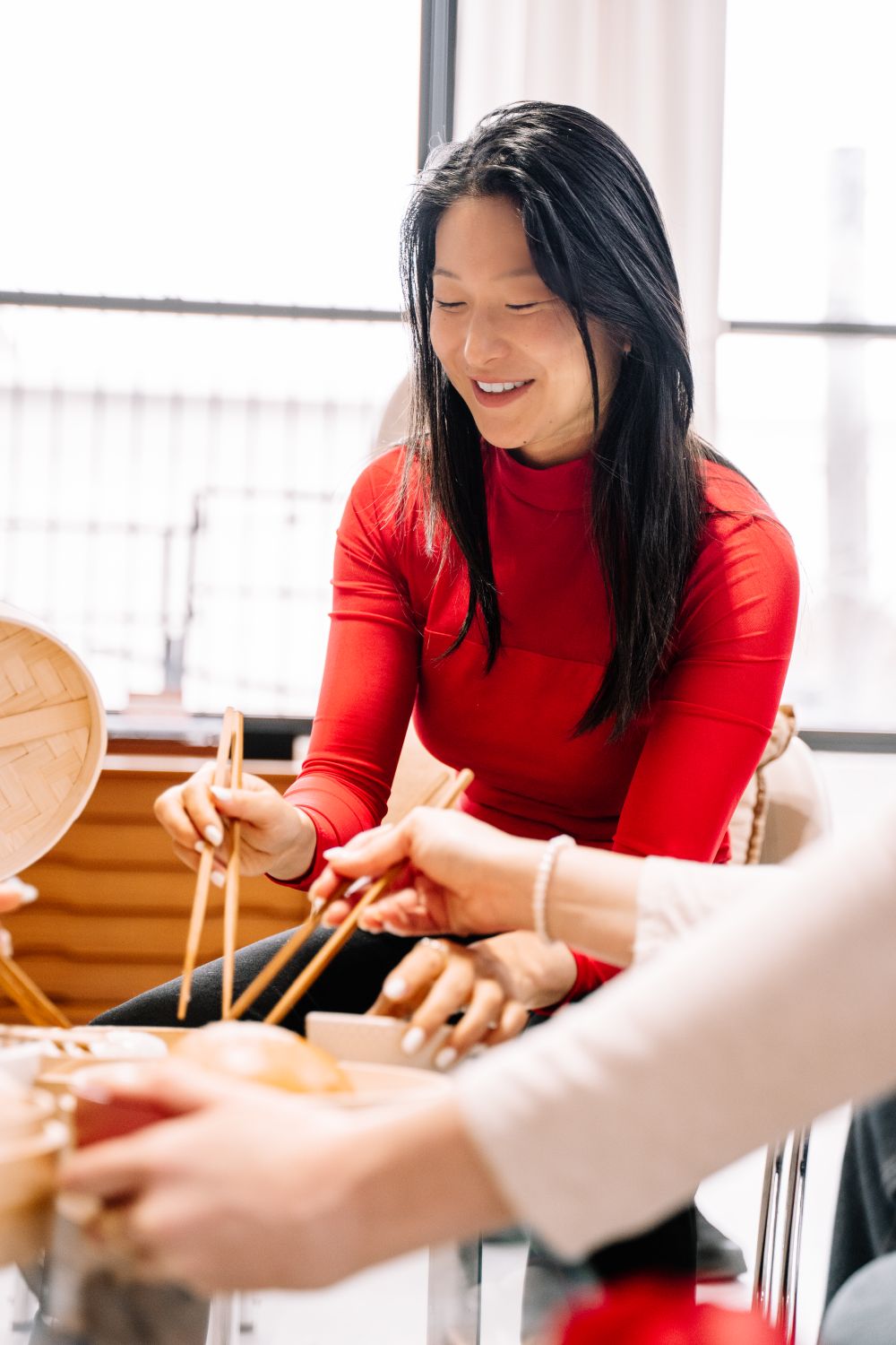 An Asian woman meeting people through a shared meal with a diverse group of friends